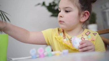 Ev mutfağında paskalya yumurtası boyayan okul çağındaki çocuk. Paskalya bahar gelenekleri. Ağır çekim. Yüksek kalite 4k görüntü