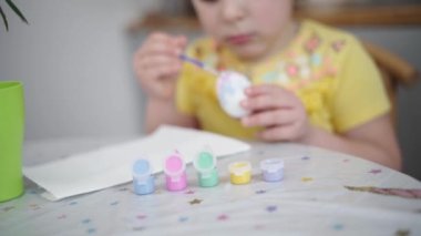 Ev mutfağında paskalya yumurtası boyayan okul çağındaki çocuk. Paskalya bahar gelenekleri. Ağır çekim. Yüksek kalite 4k görüntü