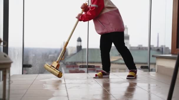 Mädchen Vorschulalter Putzen Balkonboden Mit Wischmopp Frühjahrsputz Konzept Hochwertiges Filmmaterial — Stockvideo