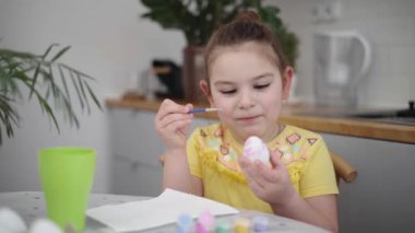 Ev mutfağında paskalya yumurtası boyayan okul çağındaki çocuk. Paskalya bahar gelenekleri. Ağır çekim. Yüksek kalite 4k görüntü