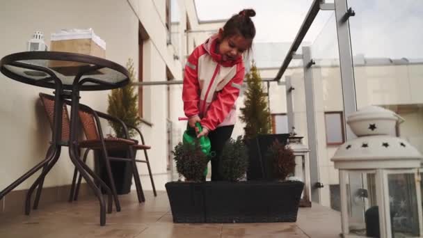 Voorschoolse Leeftijd Meisje Water Geven Planten Het Balkon Het Voorjaar — Stockvideo