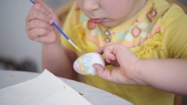 Ev mutfağında paskalya yumurtası boyayan okul çağındaki çocuk. Paskalya bahar gelenekleri. Ağır çekim. Yüksek kalite 4k görüntü