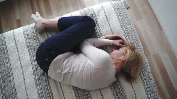 一个成熟的女人蜷曲着身子躺在床上 俯瞰全景 抑郁症 心理健康 虐待问题 高质量的照片 — 图库视频影像