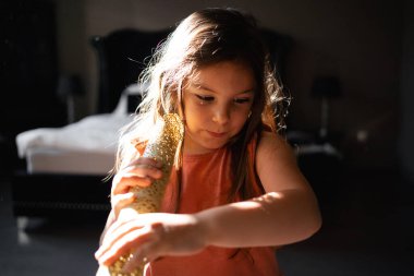 5 yaşında bir kız, sabah güneşi altında elinde güneşe bakıyor. Yüksek kalite fotoğraf