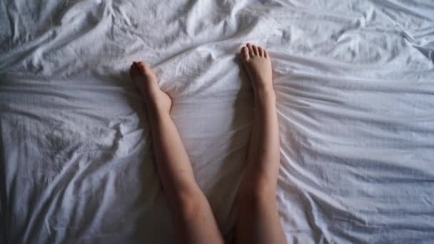 白い寝具に子供の足のトップビュー 高品質の写真 — ストック動画