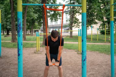 Orta yaşlı bir adam parkta direniş bantlarıyla güç egzersizleri yapıyor. Yüksek kalite fotoğraf