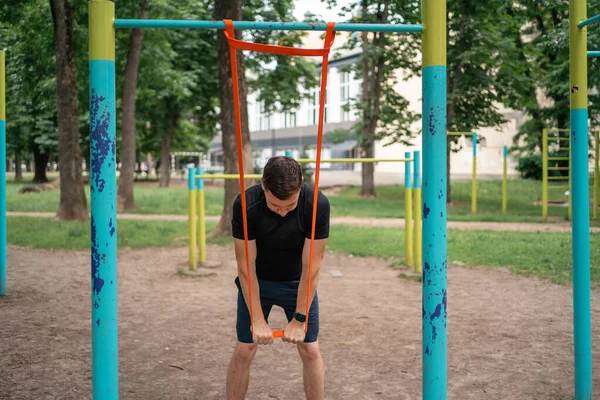 stock image Middle age man doing strength exercises with resistance bands outdoors in park . High quality photo