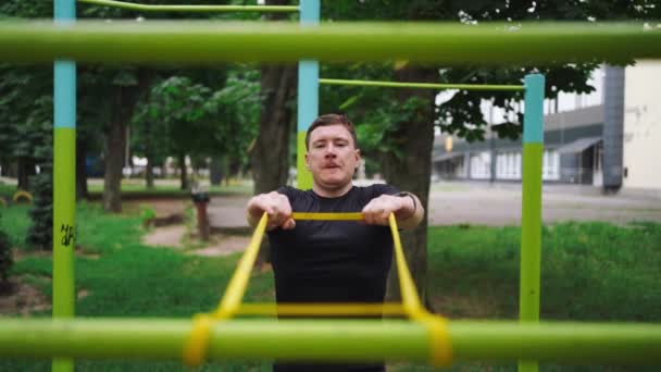 Medelålders Man Gör Styrketräning Med Motståndsband Utomhus Parken Högkvalitativt Foto — Stockvideo