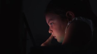 Çocuk kız çizgi film ya da sosyal medya izliyor ya da gece tablette oyun oynuyor. Gözler ekrana çok yakın. Kötü alışkanlık, uykusuzluk sorunu. Yüksek kalite 4k görüntü