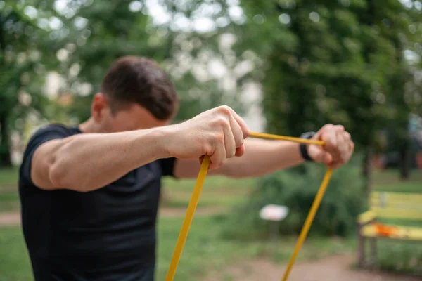 stock image Middle age man doing strength exercises with resistance bands outdoors in park . High quality photo