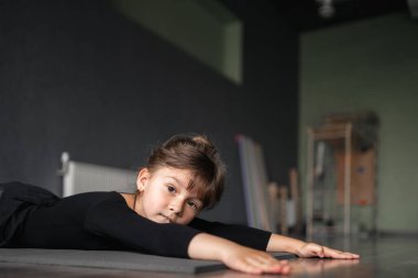 4 yaşındaki genç bir kız spor eğitimi sırasında esneme egzersizleri yapıyor. Dans ya da jimnastik. Çocukların aktif atlet eğitimi. Yüksek kalite fotoğraf