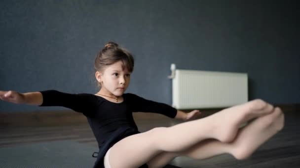 ダンス ヨガのクラスの間にコアな強さのためにV Sit運動をしている小さな子供の女の子 子供のためのヨガ 健康的なアクティブライフスタイル 子供のための物理的な開発 高品質の写真 — ストック動画