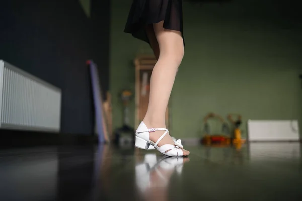 スタジオの床でダンスシューズで子供の足元を閉じる側面 子供のためのダンストレーニングクラス 女子アスリートコンセプト 高品質の写真 — ストック写真