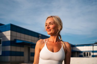 Portrait of middle age beautiful blonde woman on sunset light outdoors. Female athlete headshot outdoors. High quality photo