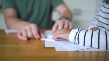 Baba ve çocuk birlikte origami yapıyorlar. Modern ebeveynlik, hafta sonu evde eğitim aktiviteleri. - Evet. Yüksek kalite 4k görüntü