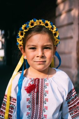 Geleneksel Ukrayna kıyafetleri ve çiçek çelengi giyen kız çocuğu gün ışığında dışarıda dua ediyor. Geleneksel Ukrayna kültürü, Slav çocuk. Yüksek kalite fotoğraf