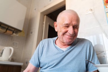 Mutfakta gülümseyen yaşlı bir adamın yakın plan portresi. Evde mutlu emeklilikler. - Evet. Yüksek kalite fotoğraf