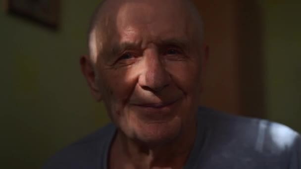 ハッピーシニアの肖像画が自宅で微笑んでいる 80歳の男性が日光浴で引退した 高品質の4K映像 — ストック動画