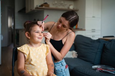 Pembe göz kalemiyle çocuk makyajı yapan bir makyöz. Küçük kız partisi ya da doğum günü hazırlığı. - Evet. Yüksek kalite fotoğraf