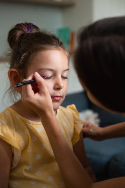 Pembe göz kalemiyle çocuk makyajı yapan bir makyöz. Küçük kız partisi ya da doğum günü hazırlığı. - Evet. Yüksek kalite fotoğraf