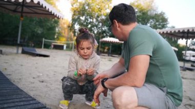 Baba ve kız çocuk birlikte dışarıda, nehrin kenarında vakit geçiriyorlar. 5-6 yaşındaki kız babasıyla konuşuyor. Yüksek kalite 4k görüntü