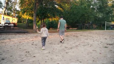 Baba ve çocuk bir ormanda ve nehir kıyısında yürüyorlar, birlikte ailece güzel vakit geçiriyorlar. Doğaya yakın. Yüksek kalite 4k görüntü