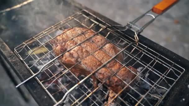 網でBbqグリルにビーフステーキをクローズアップ スモークとホットコール 屋外の肉料理の準備 高品質の4K映像 — ストック動画