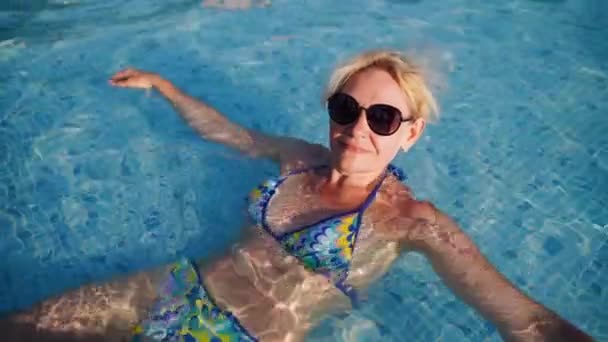 プールサイドの成熟した女性 夏の暑い気候はリラックスします プールでの休暇 健康的なライフスタイルのための水泳活動 高品質の4K映像 — ストック動画