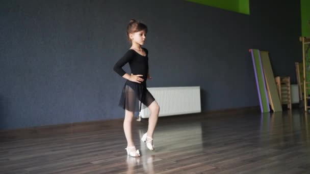 Κορίτσι Παιδί Στέκεται Μαύρο Σπορ Κοστούμι Στο Στούντιο Χορού Κατά — Αρχείο Βίντεο