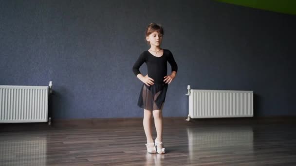 Κορίτσι Παιδί Στέκεται Μαύρο Σπορ Κοστούμι Στο Στούντιο Χορού Κατά — Αρχείο Βίντεο
