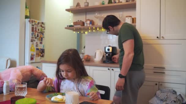 Niña Comiendo Casa Mientras Padre Cocinando Preparando Café Paternidad Moderna — Vídeo de stock