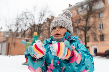 Kışın kar parkında oynayan 5-6 yaşlarında bir kız çocuğu. Yüksek kalite fotoğraf