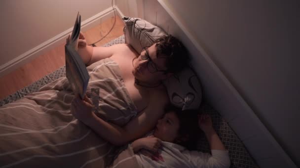 Дорослий Читає Книжку Ліжку Дитиною Вночі Високоякісна Фотографія — стокове відео