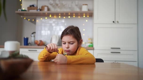 心神不宁的小女孩穿着一件黄色衬衫在家里吃饭 高质量的4K镜头 — 图库视频影像