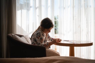 Çocuk evde deniz kabukları üzerinde yaratıcı sanatlar yapıyor, boyuyor ve çıkartmalar yapıyor. - Evet. Yüksek kalite fotoğraf
