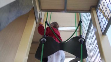Çocuk bir oyun parkına tırmanıyor. Ağ halat yapısında. - Evet. Yüksek kalite fotoğraf