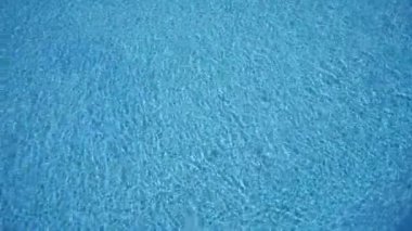 Havuzun dalgalanan sularının yakın çekim görüntüsü büyüleyici, sakin bir mavi desen yaratıyor. Yüksek kalite 4k görüntü