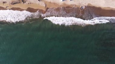 Okyanus ve karanın huzurlu arayüzü Costa Del Sol, Marbella, Endülüs, İspanya, Las Chapas Dunes 'u tasvir eden köpüklü dalgaların hava görüntüleri yavaşça kumlu bir sahile çarpıyor. Yüksek kalite 4k görüntü
