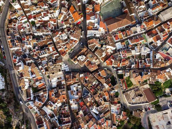 Overhead view of the curved streets and rooftops in Ojen, revealing the intricate layout of this Andalusian town. High quality photo
