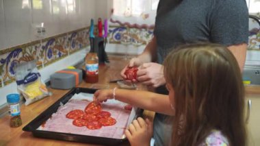  Bir baba ve küçük kızı mutfakta kahvaltı hazırlıyor, birlikte güzel vakit geçiriyorlar. Sabah ışığı pencereden süzülüyor. Yüksek kalite 4k görüntü