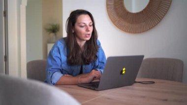 Mavi kot gömlekli bir kadın evde çalışırken kendini stresli ve bunalmış hissediyor. Yüksek kalite 4k görüntü