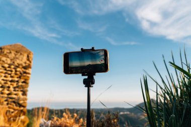 Akıllı telefon bir tripoda monte edilerek İspanya 'nın Malaga eyaletindeki Endülüs' te günbatımını kaydetti. Mavi gökyüzü ve sıcak tonlar sahneyi vurguluyor. Yüksek kalite fotoğraf