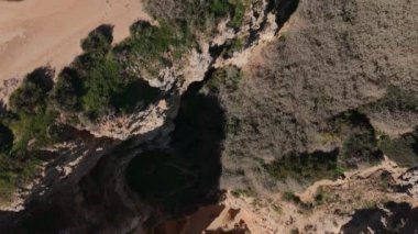 Algarve sahil şeridine geniş bir hava manzarası, engebeli uçurumlar ve sakin, yeşil sular. Huzurlu ve resimli bir seyahat yeri. Yüksek kalite 4k görüntü