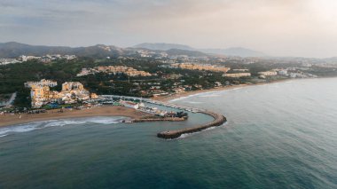 Scenic aerial view of Cabopino beach, marina, and surrounding residential areas under soft sunrise light in Andalusia, Spain. High quality photo clipart