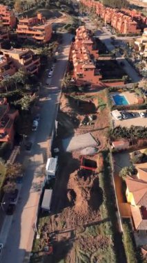 Tepeler ve geniş mavi gökyüzü ile çevrili bir Akdeniz mahallesindeki canlı turuncu villaların hava manzarası. Yüksek kalite 4k görüntü