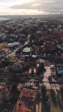 Tepeler ve geniş mavi gökyüzü ile çevrili bir Akdeniz mahallesindeki canlı turuncu villaların hava manzarası. Yüksek kalite 4k görüntü