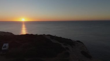 Gün batımında Algarve sahil şeridinin manzarasında dramatik uçurumlar ve engin Atlantik Okyanusu var. Minibüs hayatı, yolculuklar ve macera arayanlar için sakin bir inziva. Yüksek kalite 4k