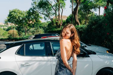 Lüks hayat: rahat bir zarafetle otomotiv yaşam tarzını modern moda estetiğiyle harmanlayan kendine güvenen bir kadın. Yüksek kalite fotoğraf