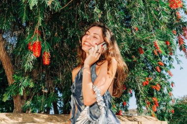 Çabasız dijital yaşam tarzı: doğada modern bir kadın, teknolojiyi, modayı ve Akdeniz yaz estetiğini harmanlıyor. Yüksek kalite fotoğraf