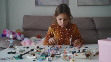 Evde, rahat oturma odasında yaratıcı oyuncaklar inşa eden çocuk..